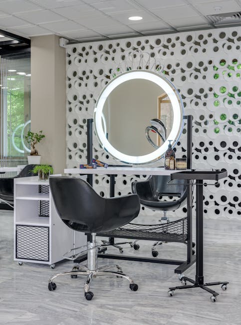 Chic salon setup featuring sleek chairs and illuminated vanity mirror.