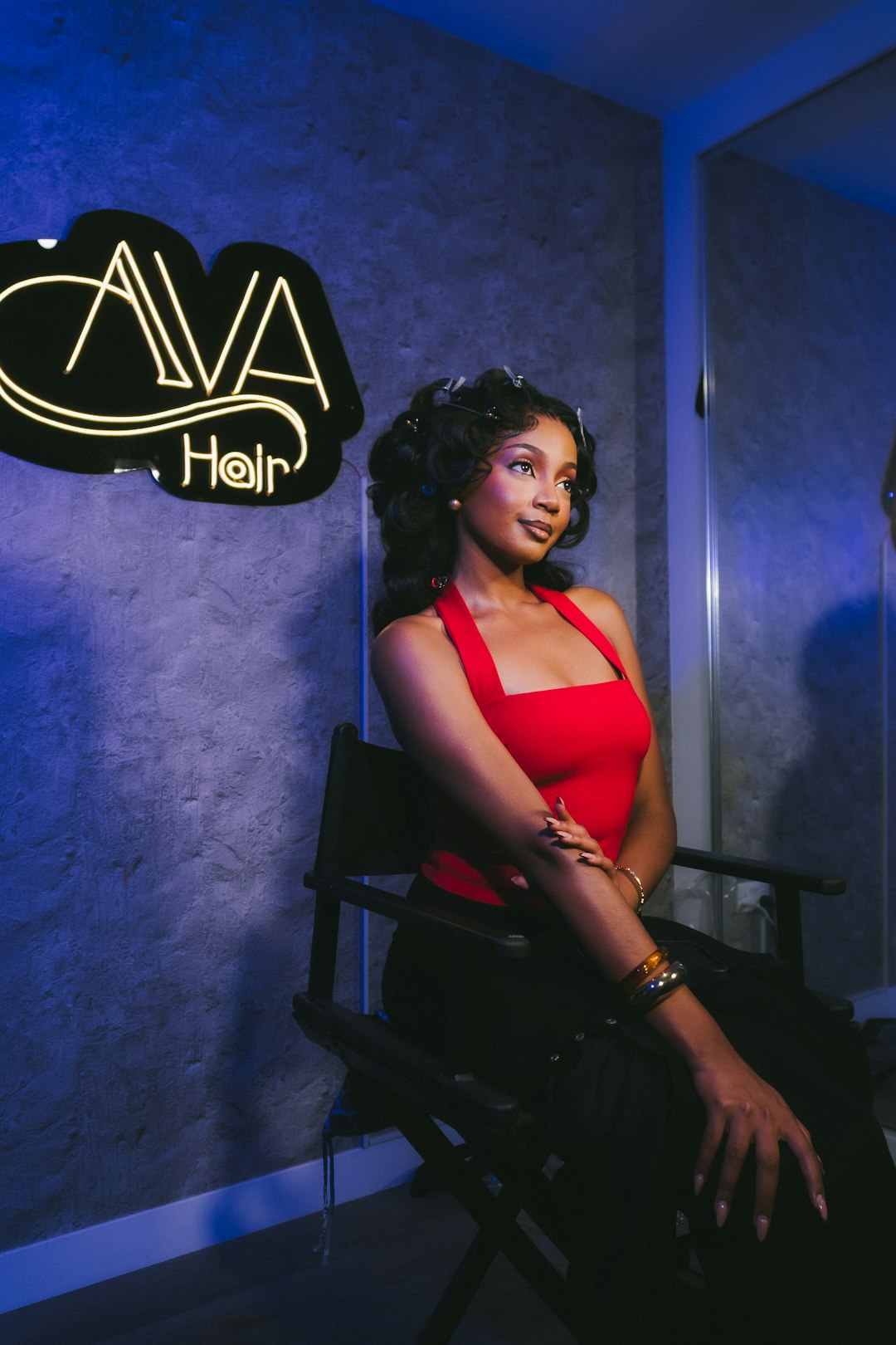 Woman with styled hair sitting in a chair.