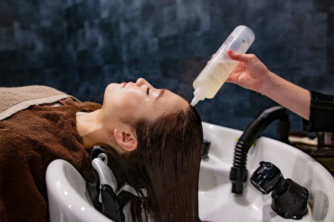a woman getting her hair washed with a hair dryer