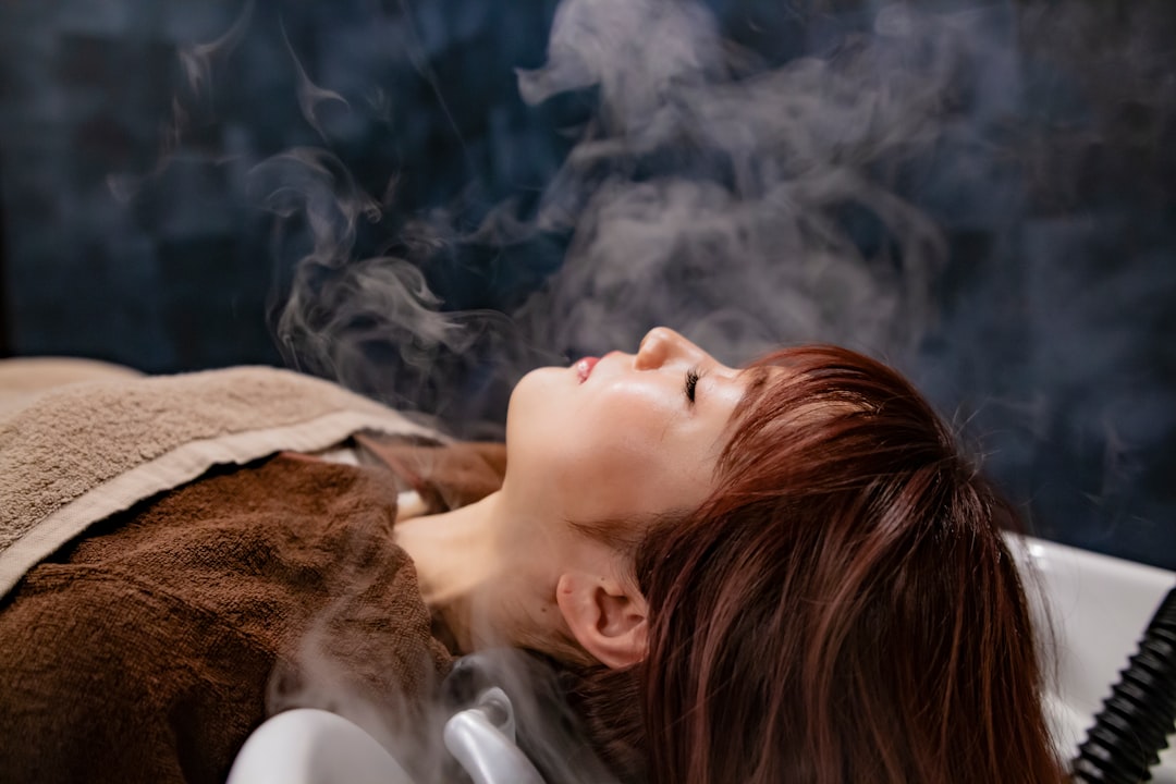 a woman laying in a bathtub with steam coming out of her face