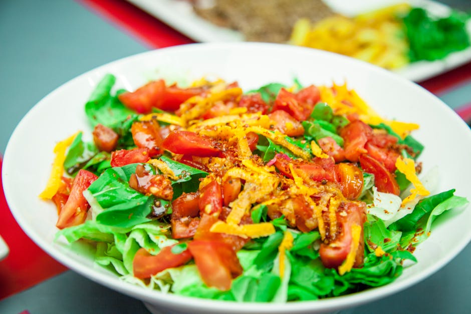 Colorful salad with tomatoes, lettuce, and carrots, showcasing fresh ingredients.
