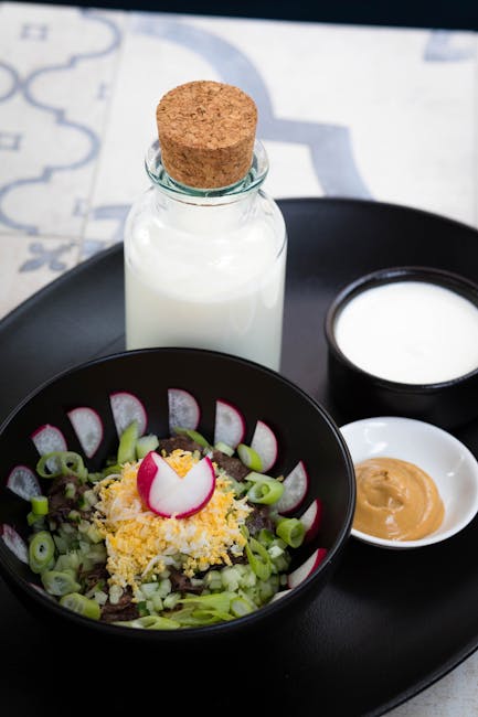 Fresh radish salad with milk and creamy toppings on a black tray, perfect for a healthy meal.
