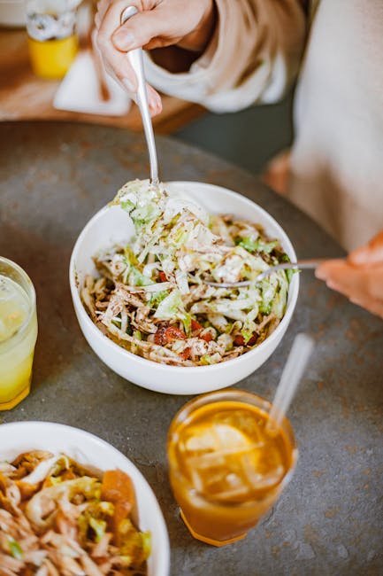 Close-up of a healthy chicken salad bowl with iced tea and lemonade on a table, perfect for dieting.