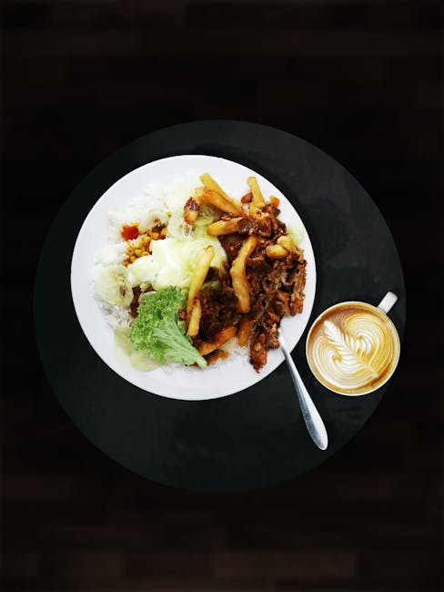 Top view of a meal with fries, lettuce, and coffee cup on a black background.