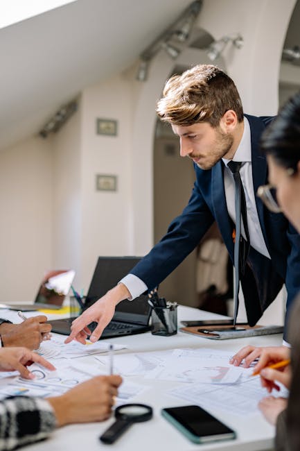 Diverse business team planning together with documents, laptop, and teamwork in modern office.