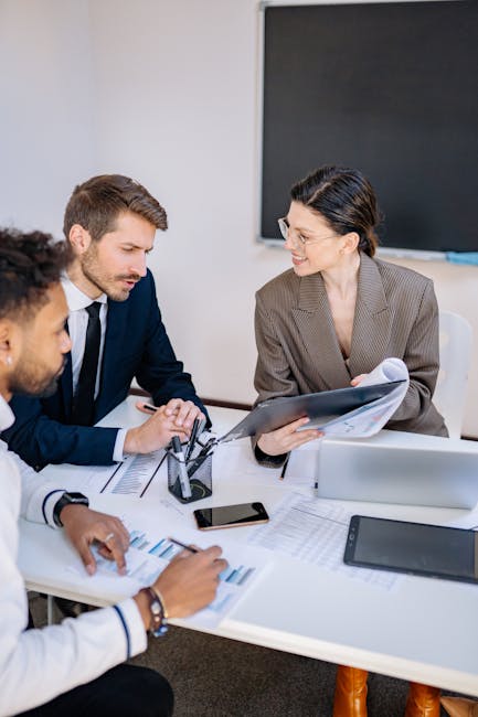 Three professionals engaged in a productive office meeting sharing ideas and discussing strategies.