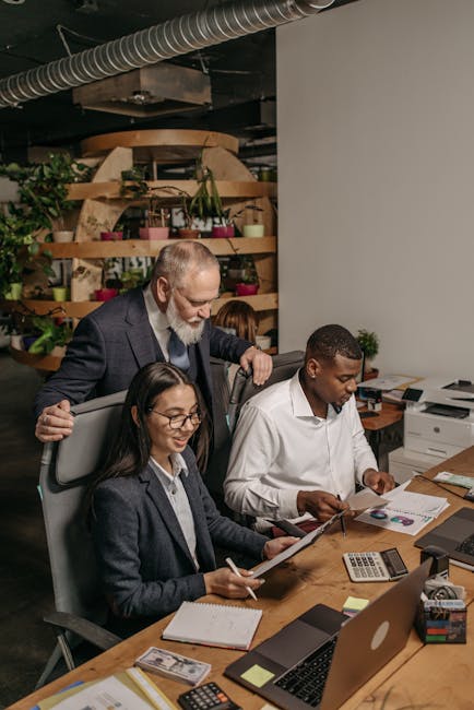 Professional team collaborating in a modern office environment with documents and technology.