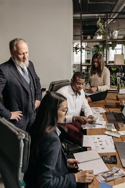 Office team working together on a business project with documents and laptops.
