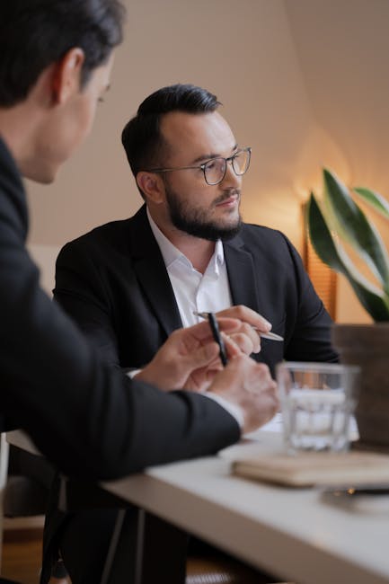 Two men in a business meeting, discussing ideas indoors with intense concentration.