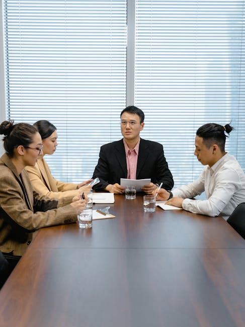 Group of professionals in a boardroom engaged in a focused business meeting.