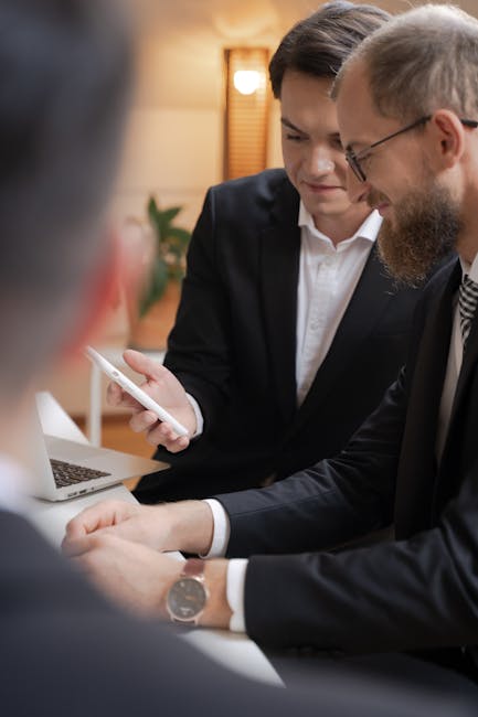 Business professionals interacting with a smartphone during an office meeting.