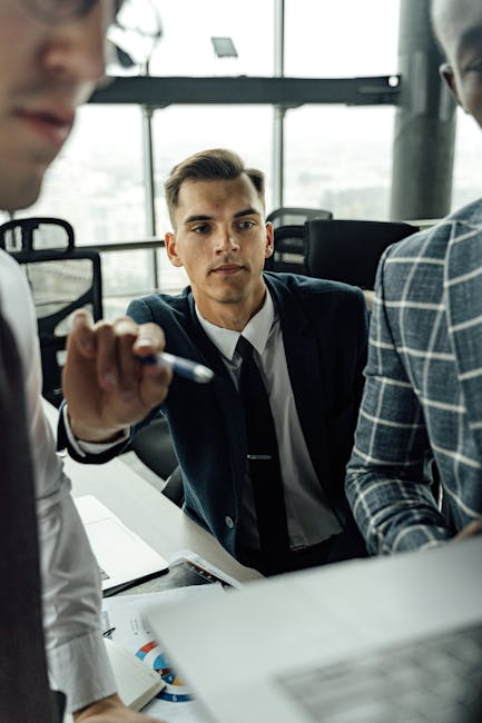 Businessman attentively listening during a modern office meeting with colleagues.