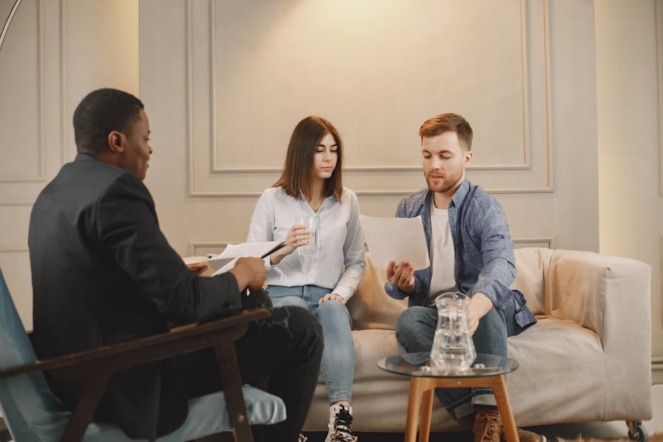Therapist counseling couple with documents in contemporary office setting.