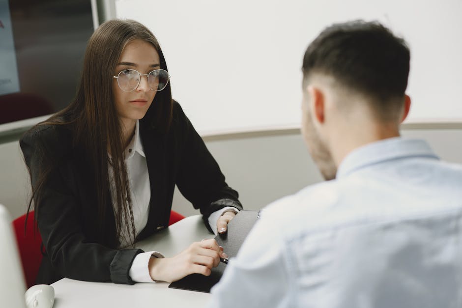 Two professionals engage in a serious business meeting at a modern office setting.