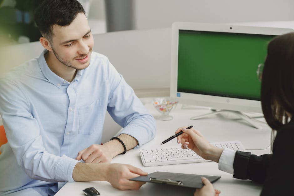 Colleagues discussing project details at a modern office desk