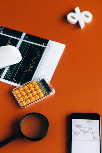 Desk setup with calculator, graphs, and tools on orange surface for financial analysis.