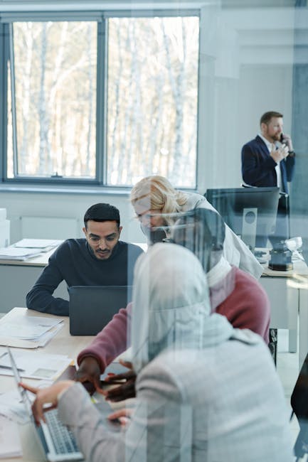 Colleagues from diverse backgrounds engaging in productive teamwork at the office.