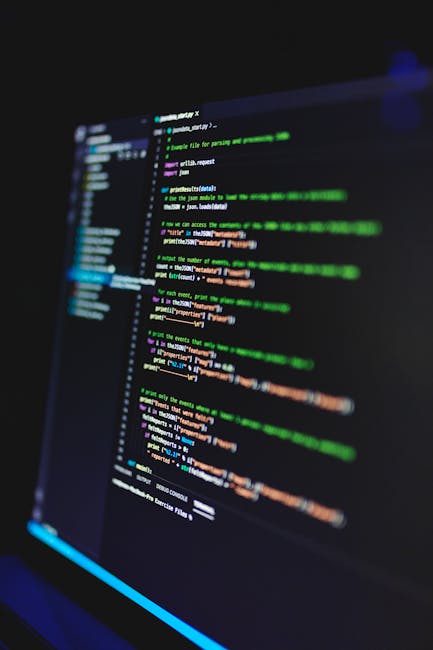 Vertical shot of colorful programming code on a screen in a dark room, highlighting technology work.