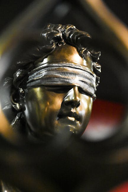 Intricate bronze sculpture with a textured blindfold, captured in moody lighting.