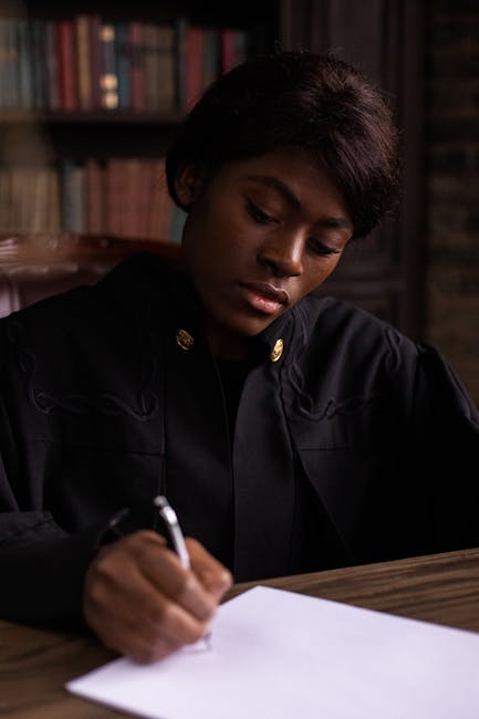 A woman deeply concentrating while writing at a desk in a library.