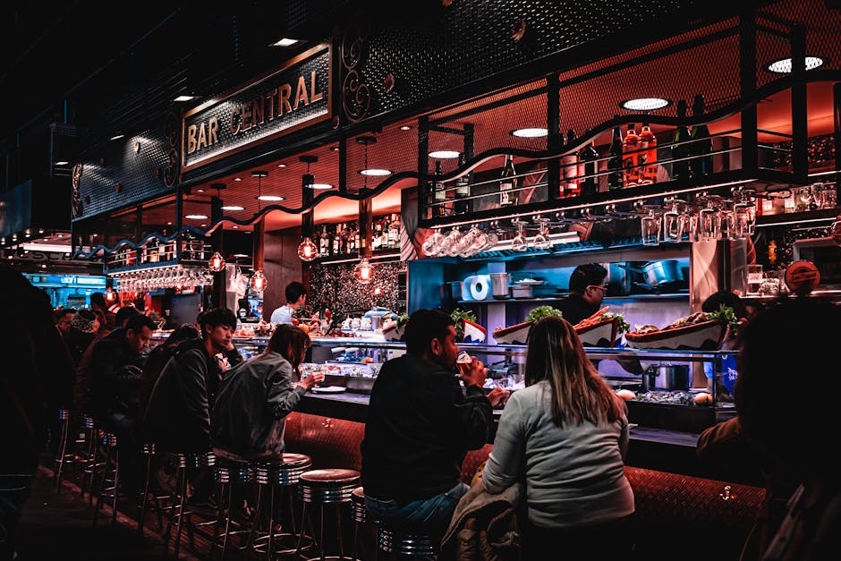 A lively evening scene at Bar Central with adults enjoying drinks and socializing in an ambient restaurant setting.