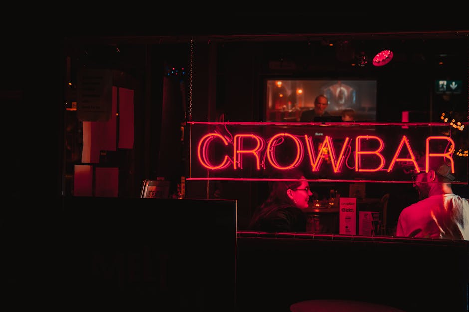 Two people enjoying a lively night at Crowbar in Dublin with vibrant neon lights.