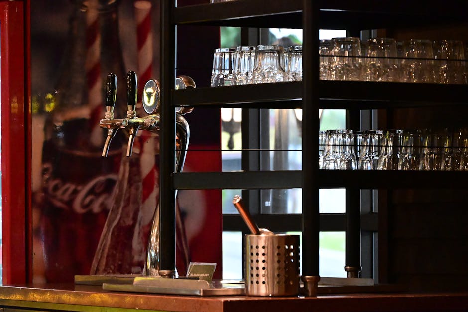 Bar counter with drink dispensers and glassware in Johor Bahru, Malaysia, creating a warm, cozy atmosphere.