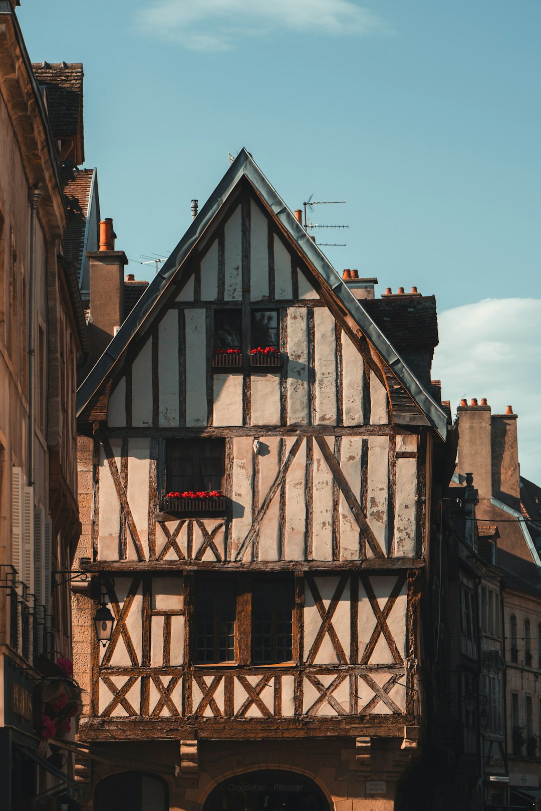 A tall building with a wooden balcony next to other buildings