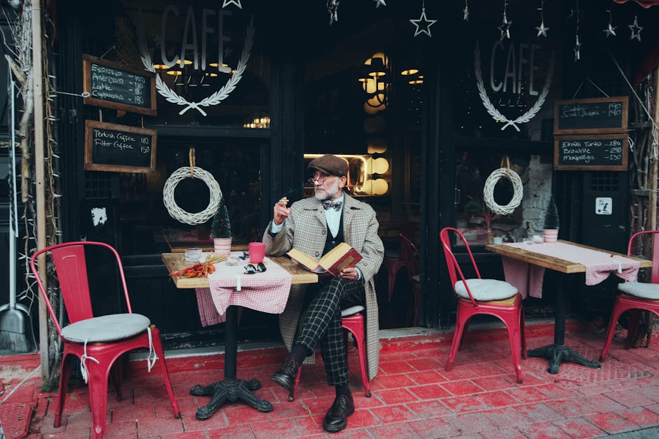 An elegantly dressed man with a book and coffee at a charming outdoor café in Istanbul, Türkiye.