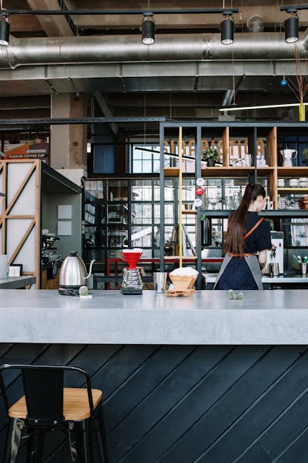 A barista in a modern loft cafe preparing pour-over coffee with precision.