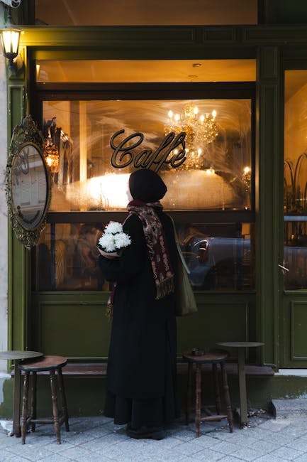 A woman, holding flowers, enjoys the cozy atmosphere outside a cafe in İstanbul.