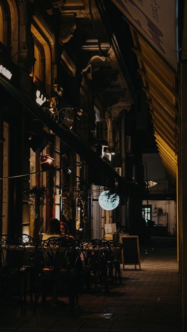 Warm and inviting outdoor café scene at night with ambient lighting and empty tables.