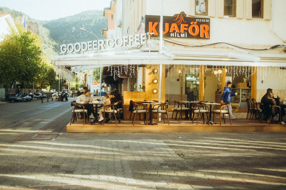 Cozy outdoor seating at Gooder Coffee on a sunny day in a lively urban area.