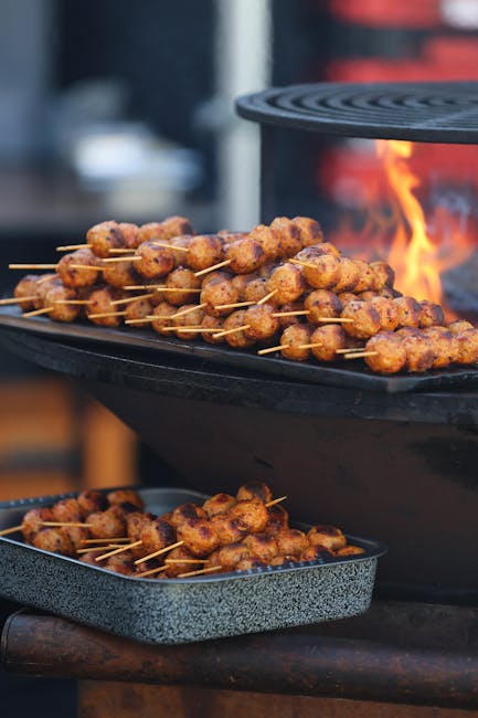Tantalizing meat skewers grilling over an open flame, perfect for outdoor BBQ events.