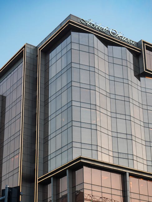 Architecture of Hotel Okura with sleek modern glass facade, captured at day.