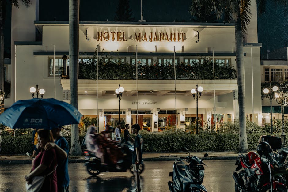 Bustling street scene outside Hotel Majapahit, Surabaya at night.