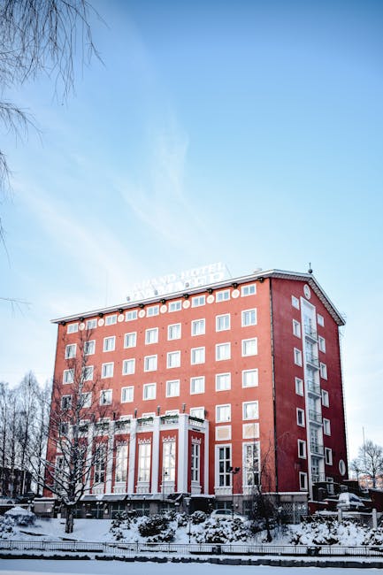 Stunning view of a red brick hotel building amidst snowy surroundings in Tampere, Finland.