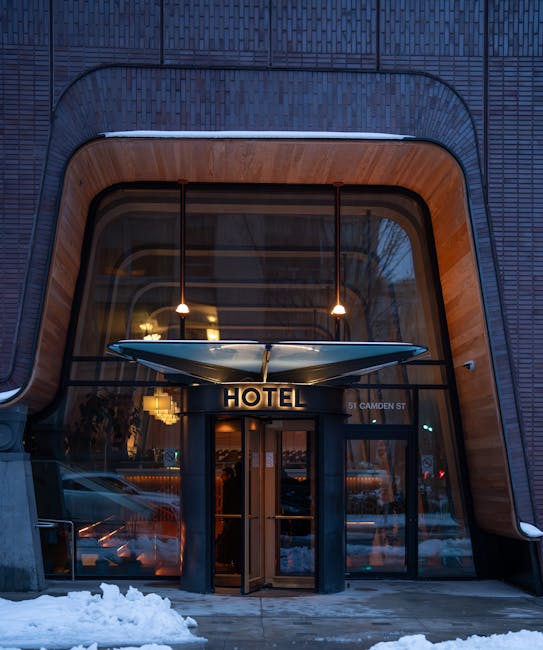 A sleek, modern hotel entrance in winter, showcasing unique architecture on Camden St, Toronto.