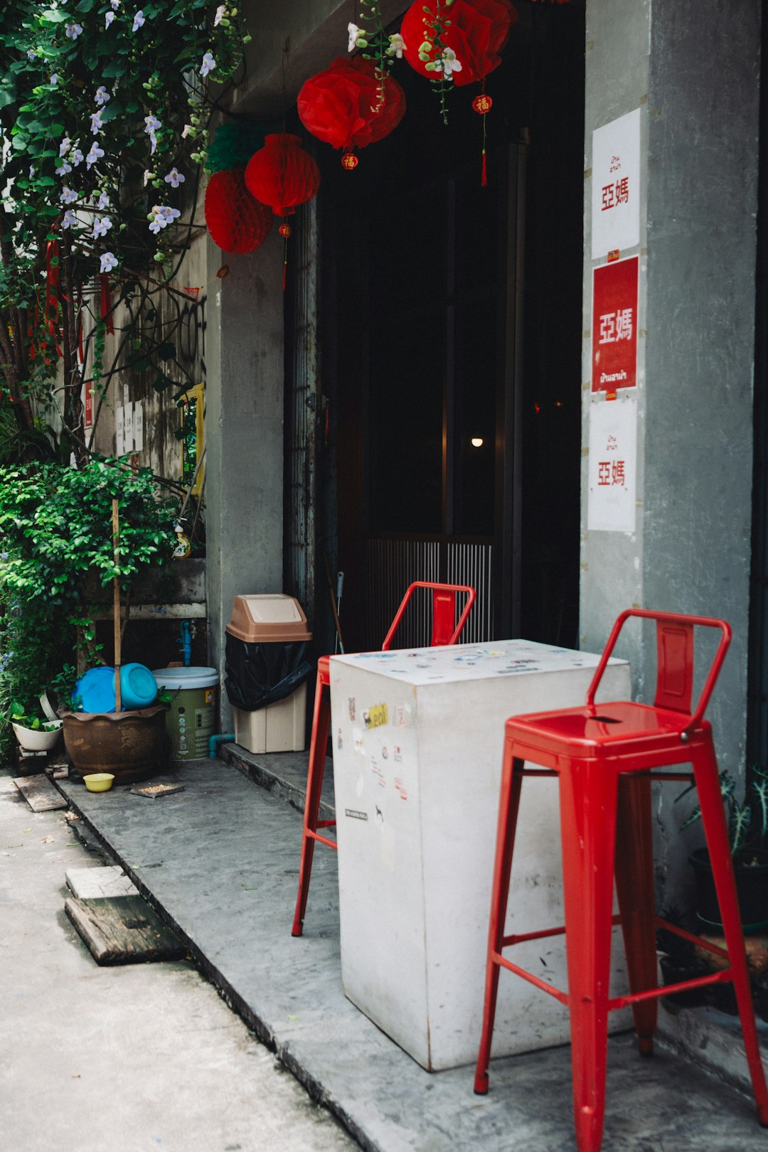 Red stools and white cooler outside building entrance