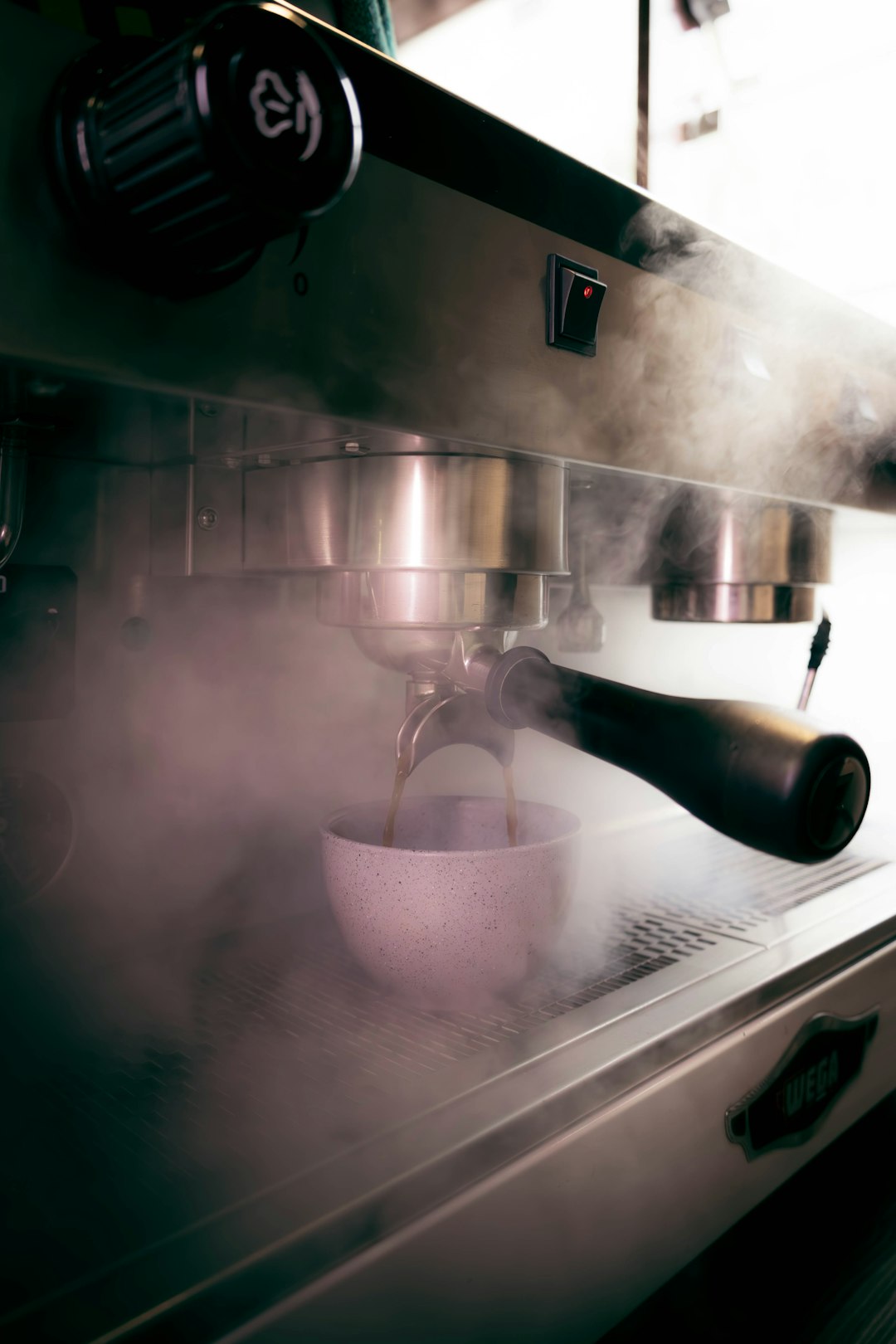 Espresso machine steaming and brewing coffee.