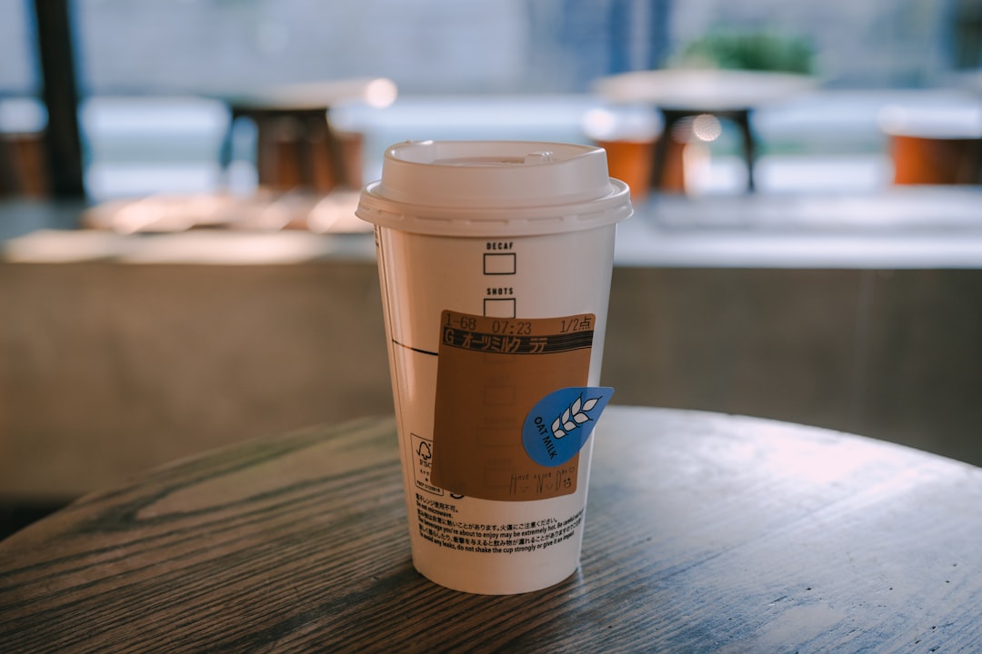 A takeaway coffee cup with a lid on a table.