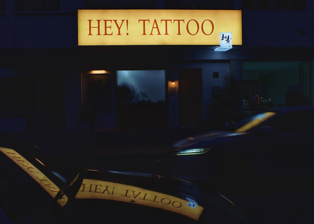 A car parked in front of a tattoo shop