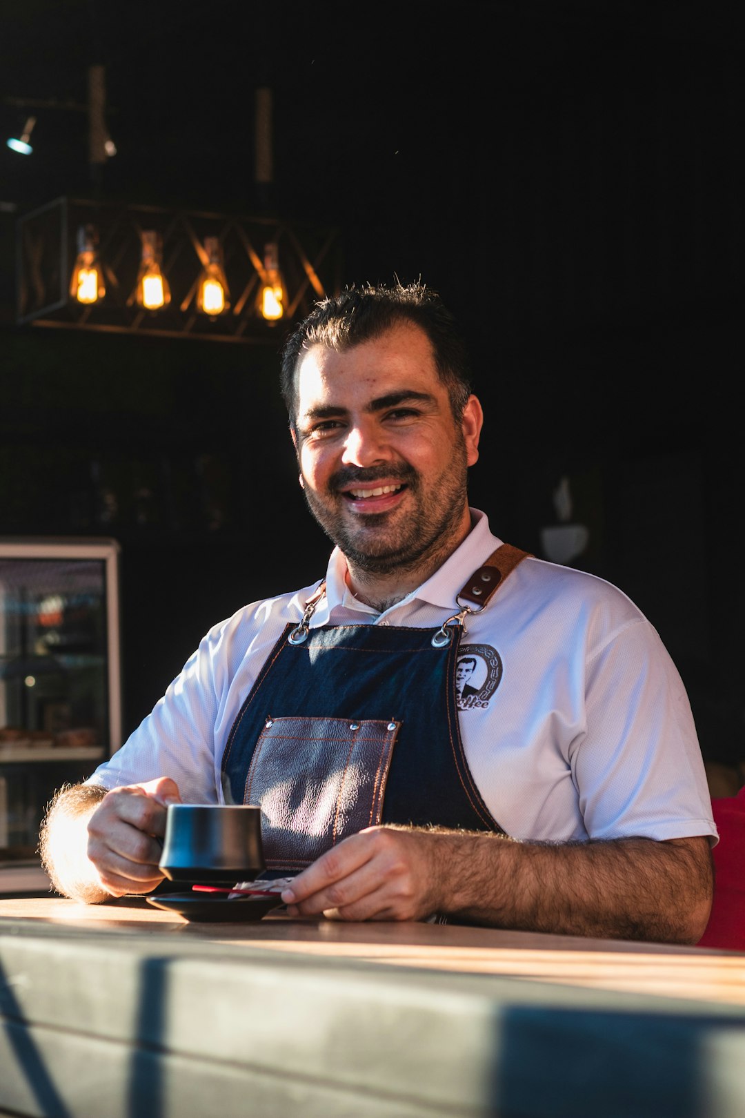 a man sitting at a table with a cup of coffee