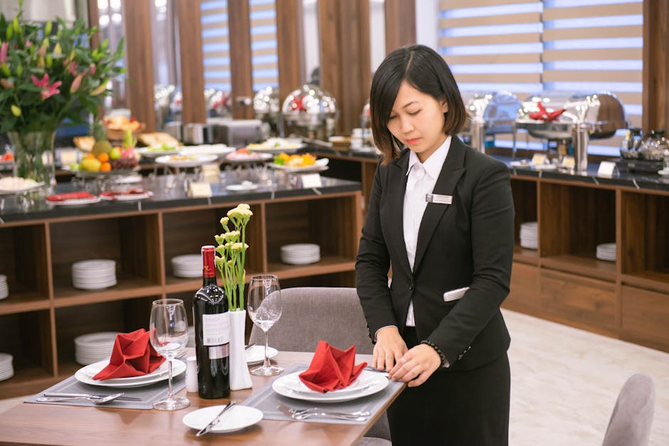 Asian waitress setting an elegant table in a Hanoi restaurant, creating a formal dining experience.