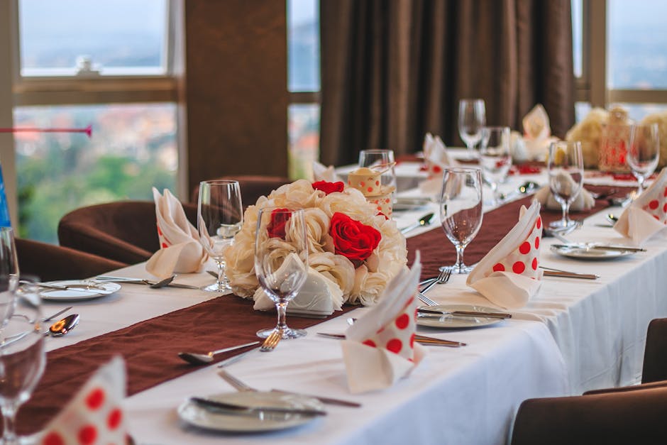 Elegant dining table with floral centerpiece and polka-dot napkins at a Kampala restaurant.