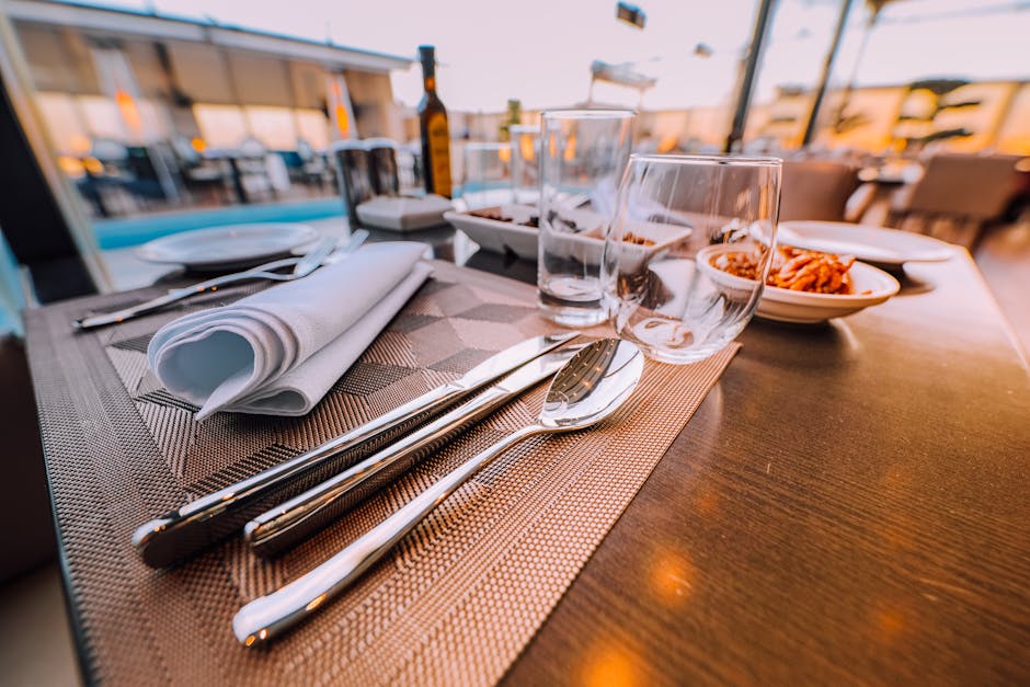Close-up of an elegant table setting at a stylish outdoor restaurant with ambient lighting.