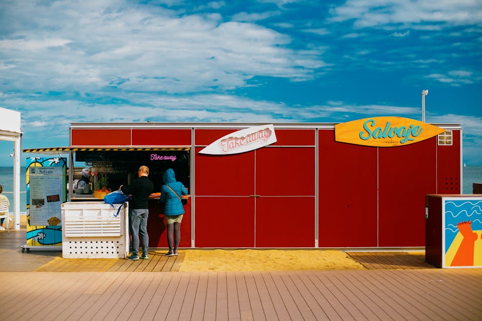 Vibrant street scene of a takeaway kiosk by the beach in Barcelona, Spain.