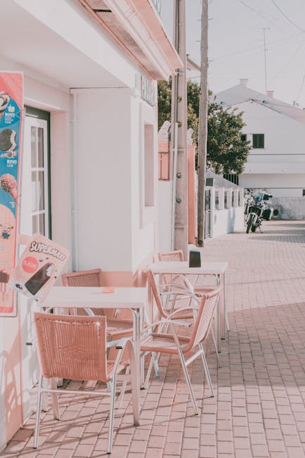 Charming outdoor cafe seating with wicker chairs on a sunny street, capturing a cozy neighborhood vibe.