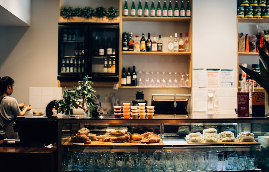 Warm café setting with sandwiches and drinks on display at the counter.