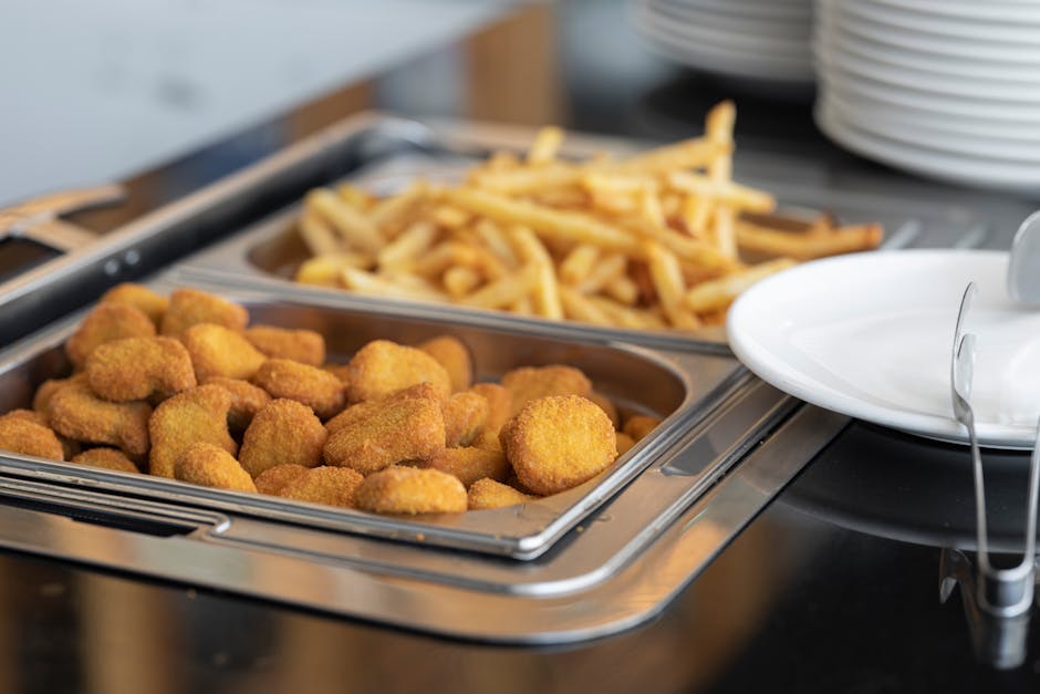 Close-up of crispy nuggets and French fries in a buffet setup, perfect for fast food or catering imagery.